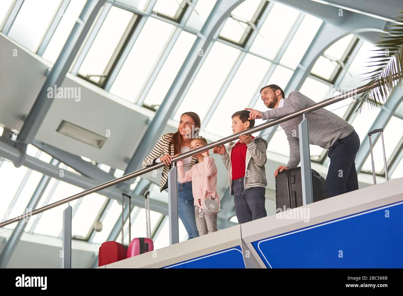 Familie mit zwei Kindern und Gepäck unterwegs im Flughafen Stockfoto