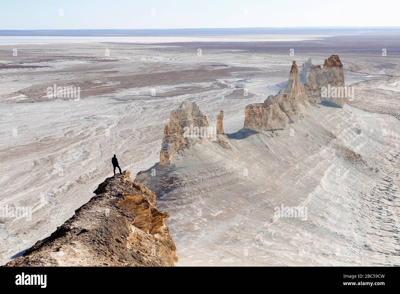 Mann auf Plateau mit Panoramablick auf Felsformationen, Ustyurt, Boszhira, Kaspische Depression Wüste, Aktau, Mangystau, Kasachstan Stockfoto