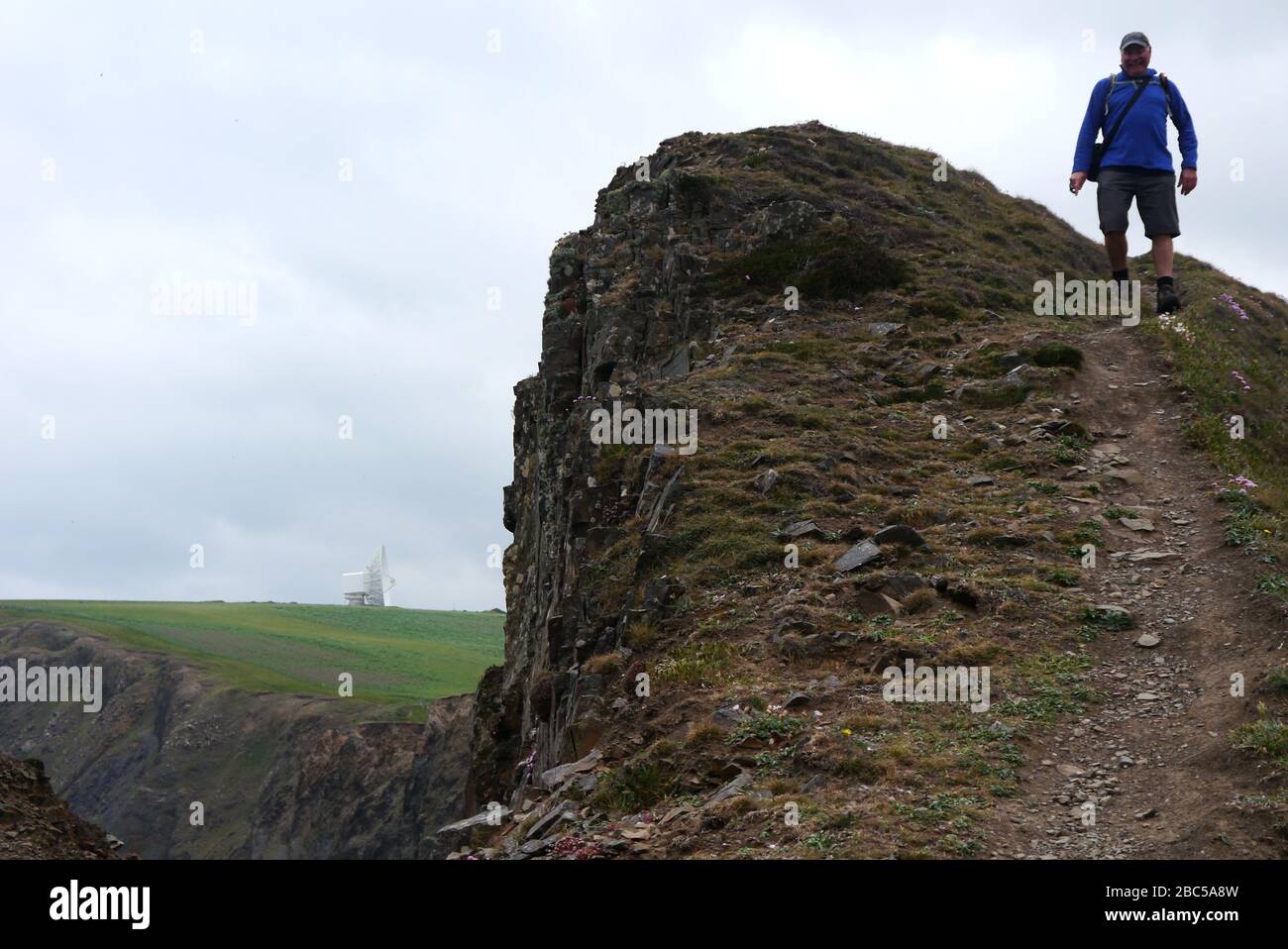 Lone man Hiker Wandern auf dem Cliff Edge am Steeple Point über Duckpool Bay auf dem South West Coast Path, North Cornwall, England, Großbritannien. Stockfoto