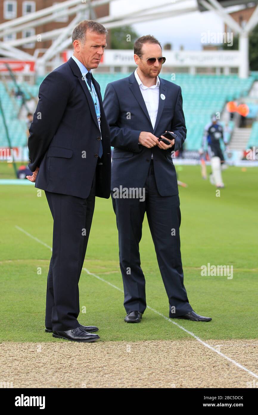 Alec Stewart (links) chattet mit dem Wettbewerbssieger, während sie das Spielfeld inspizieren Stockfoto