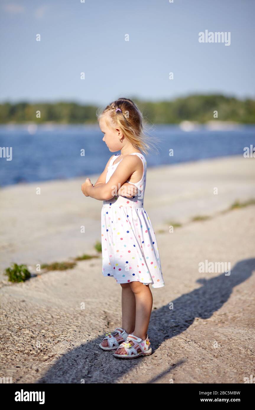 Trauriges Kind, einsames kleines Mädchen, das auf Wasser beobachtet Stockfoto