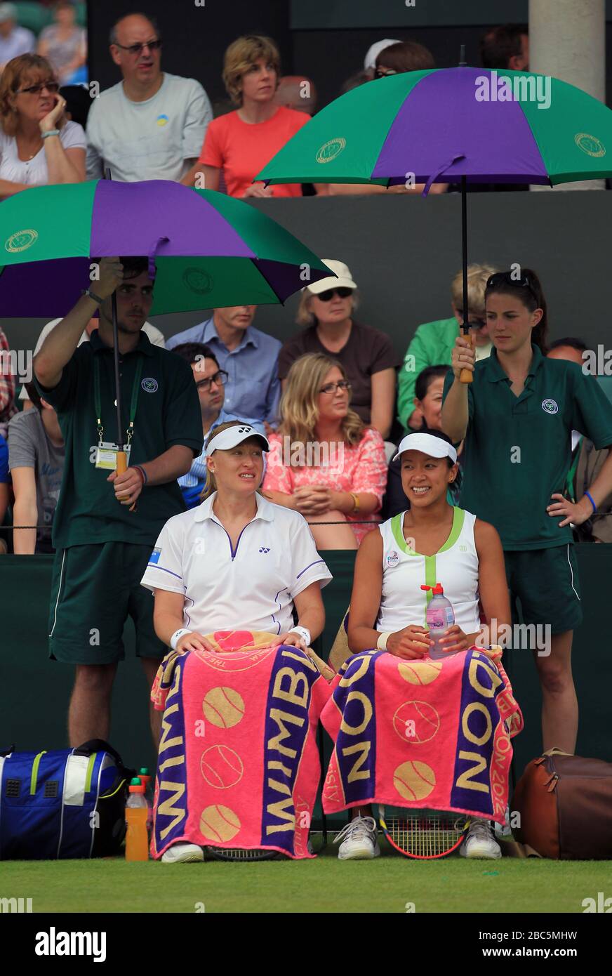 Großbritanniens Elena Baltacha (links) und Anne Keothavong unterstehen während ihres Doppelspiels gegen die Rumänen Irina-Camelia Begu und Monica Niculescu unter Regenschirmen Stockfoto