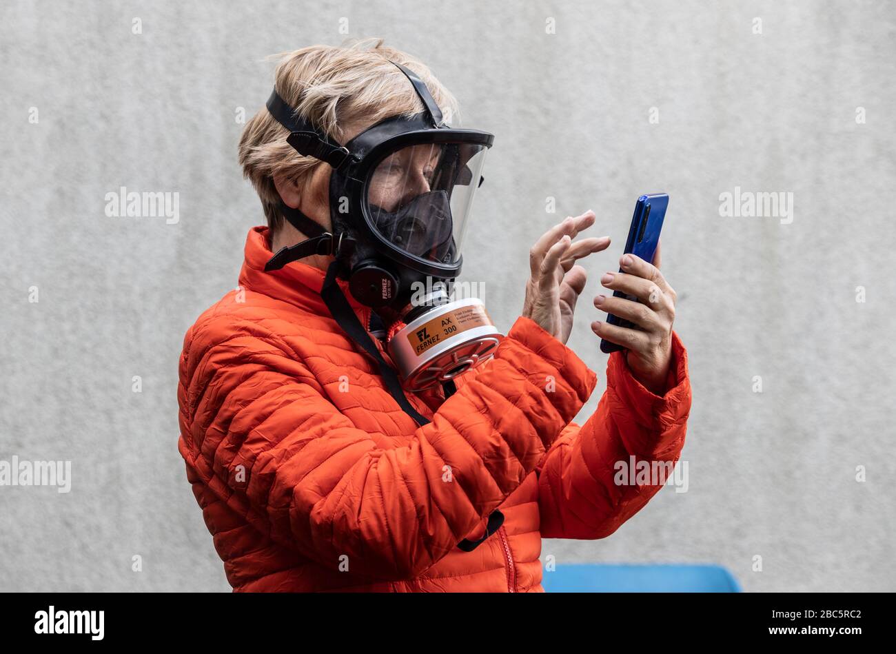 Frau mit Schutzmaske und Smartphone Stockfoto