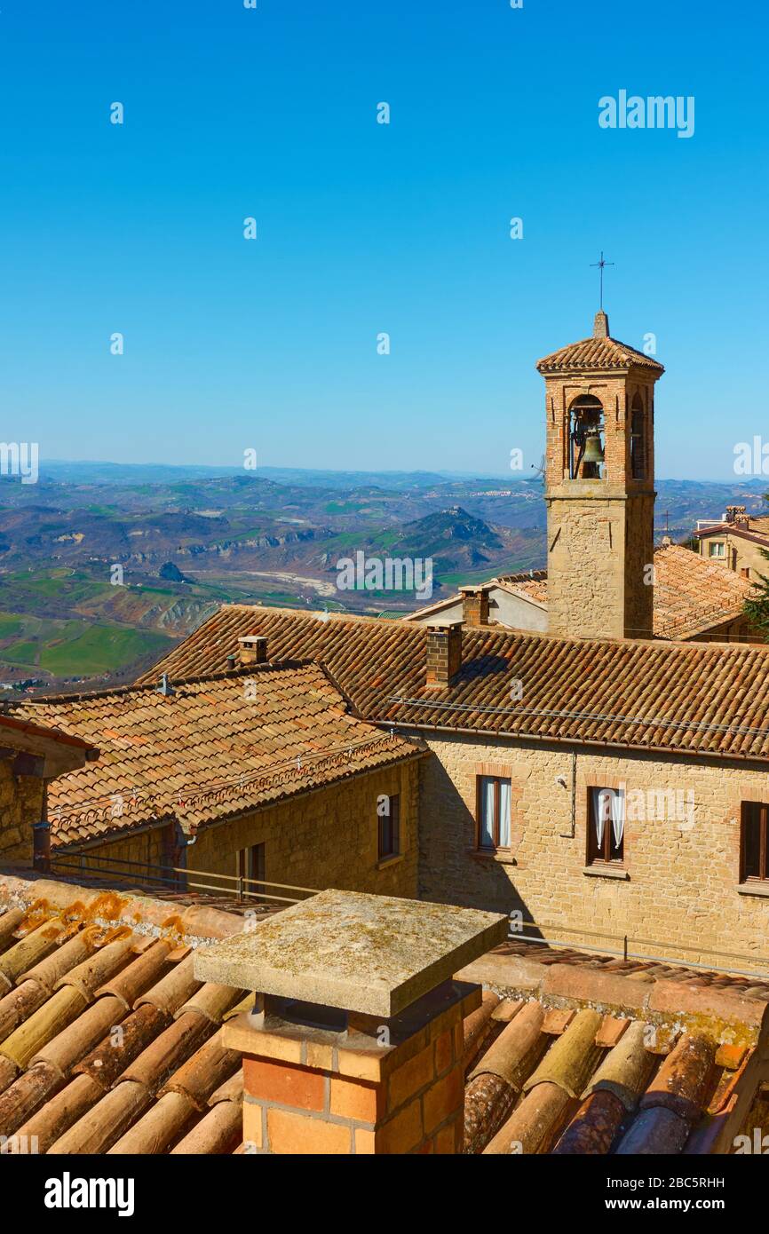 Alte Häuser mit Ziegeldächern und Kirchturm in San Marino - Landschaft, Stadtbild Stockfoto