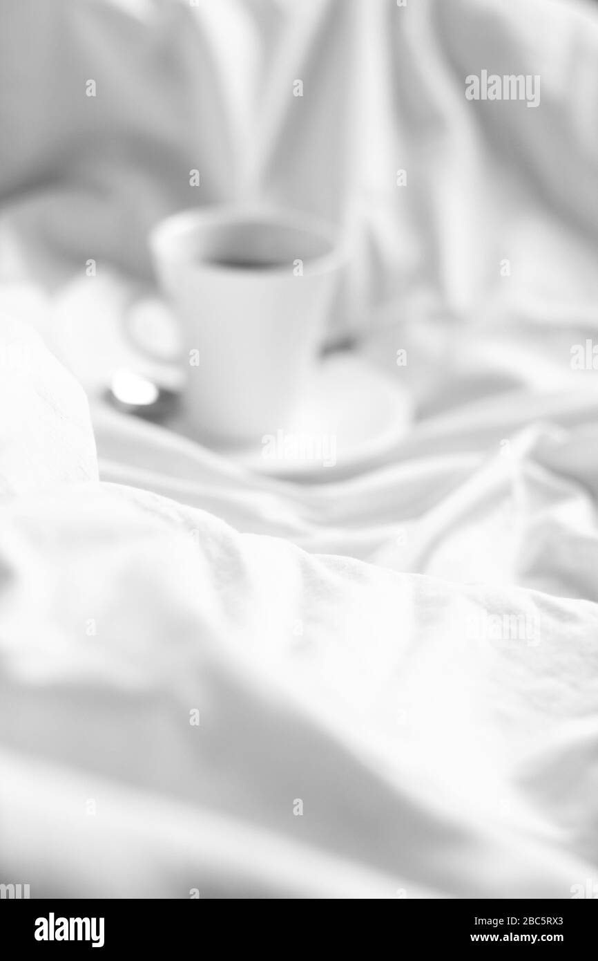 Verschwommene abstrakte Ansicht des gemütlichen, ungeschafften Betts mit Kaffee. Minimales Skandinavisches Design. Bleiben Sie Zu Hause. Stockfoto