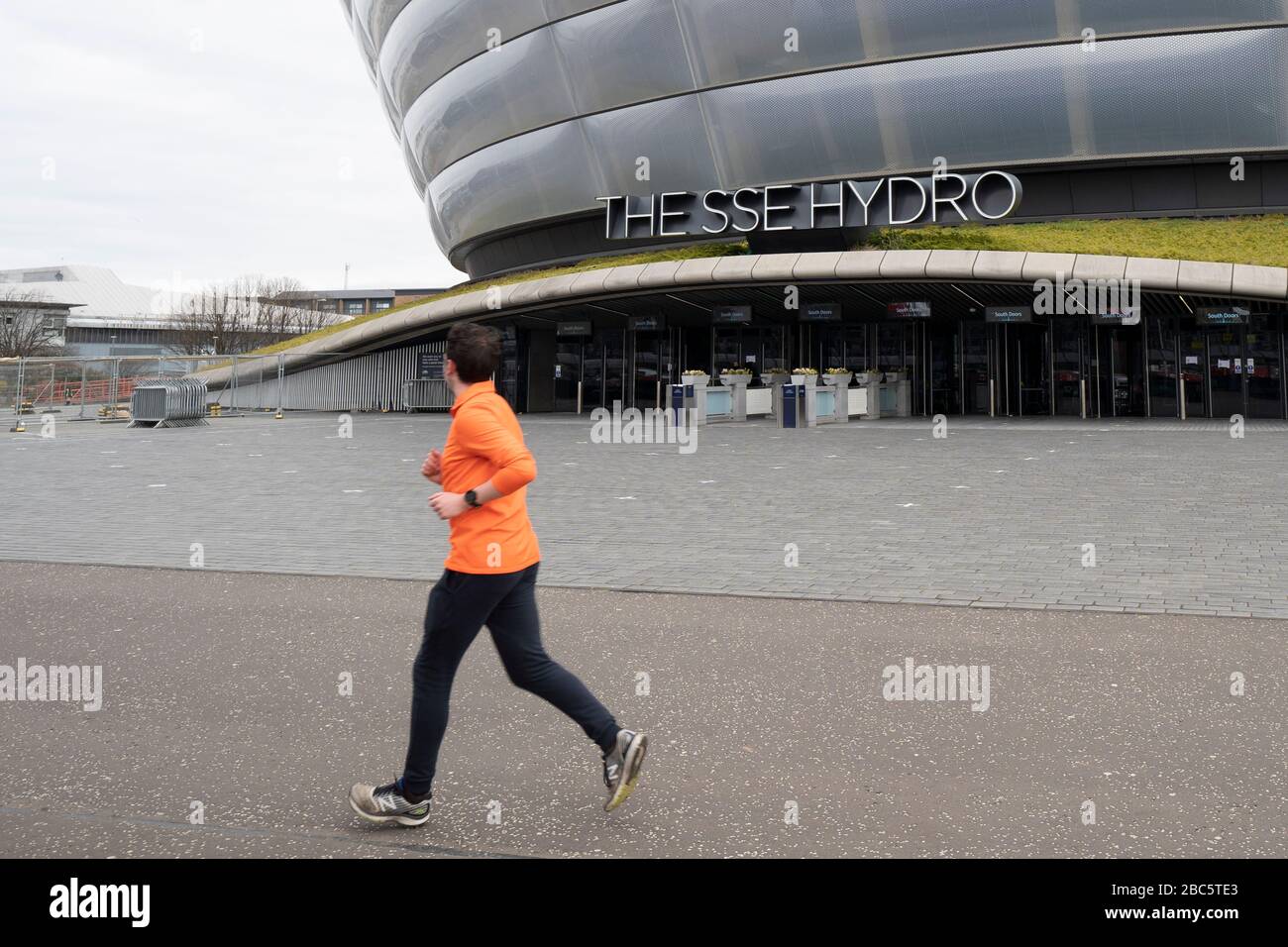 Glasgow, Schottland, Großbritannien. April 2020. Jogger läuft am SSE Hydro beim Bau des temporären NHS Louisa Jordan Field Hospital auf dem Scottish Events Campus (SEC) in Glasgow vorbei. Iain Masterton/Alamy Live News Stockfoto