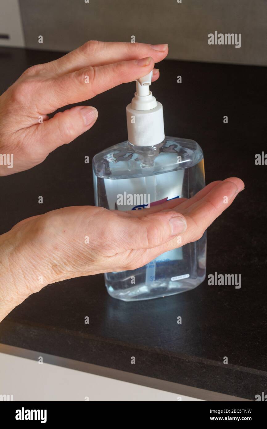 Hydro-alkoholische Gel an die Hände legen, um sie zu desinfizieren Stockfoto