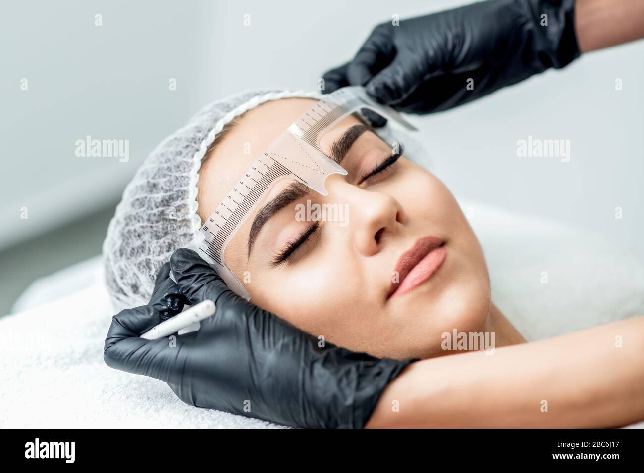 Markup mit Lineal an den Augenbrauen der yong-frau während des permanenten Make-up. Stockfoto