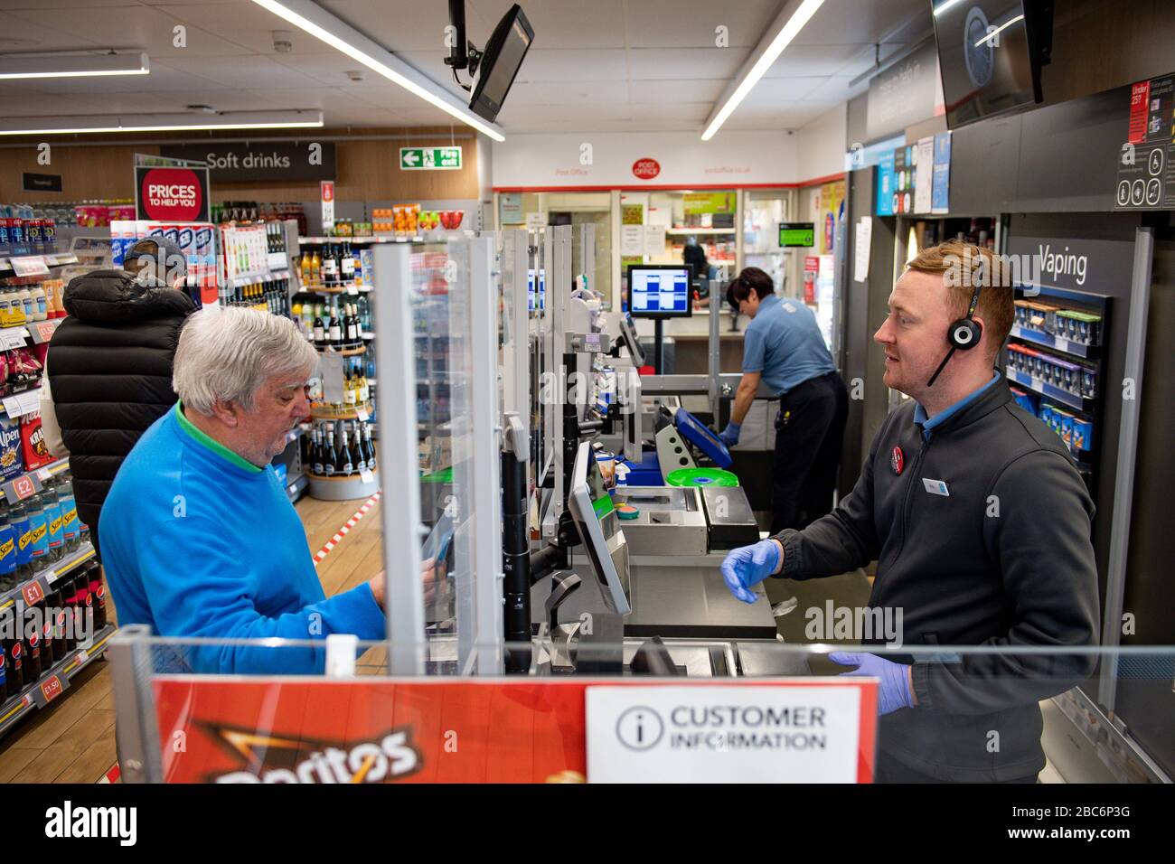 Ein klarer Bildschirm teilt Mitarbeiter und Kunden in einem Co-op-Shop in Bromsgrove, Worcestershire, im Geschäft auf. Stockfoto