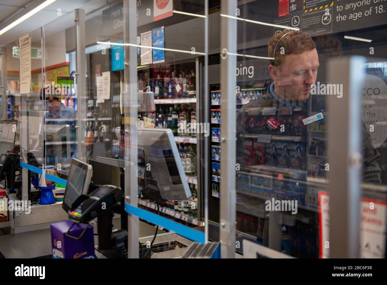 Ein klarer Bildschirm teilt Mitarbeiter und Kunden in einem Co-op-Shop in Bromsgrove, Worcestershire, im Geschäft auf. Stockfoto