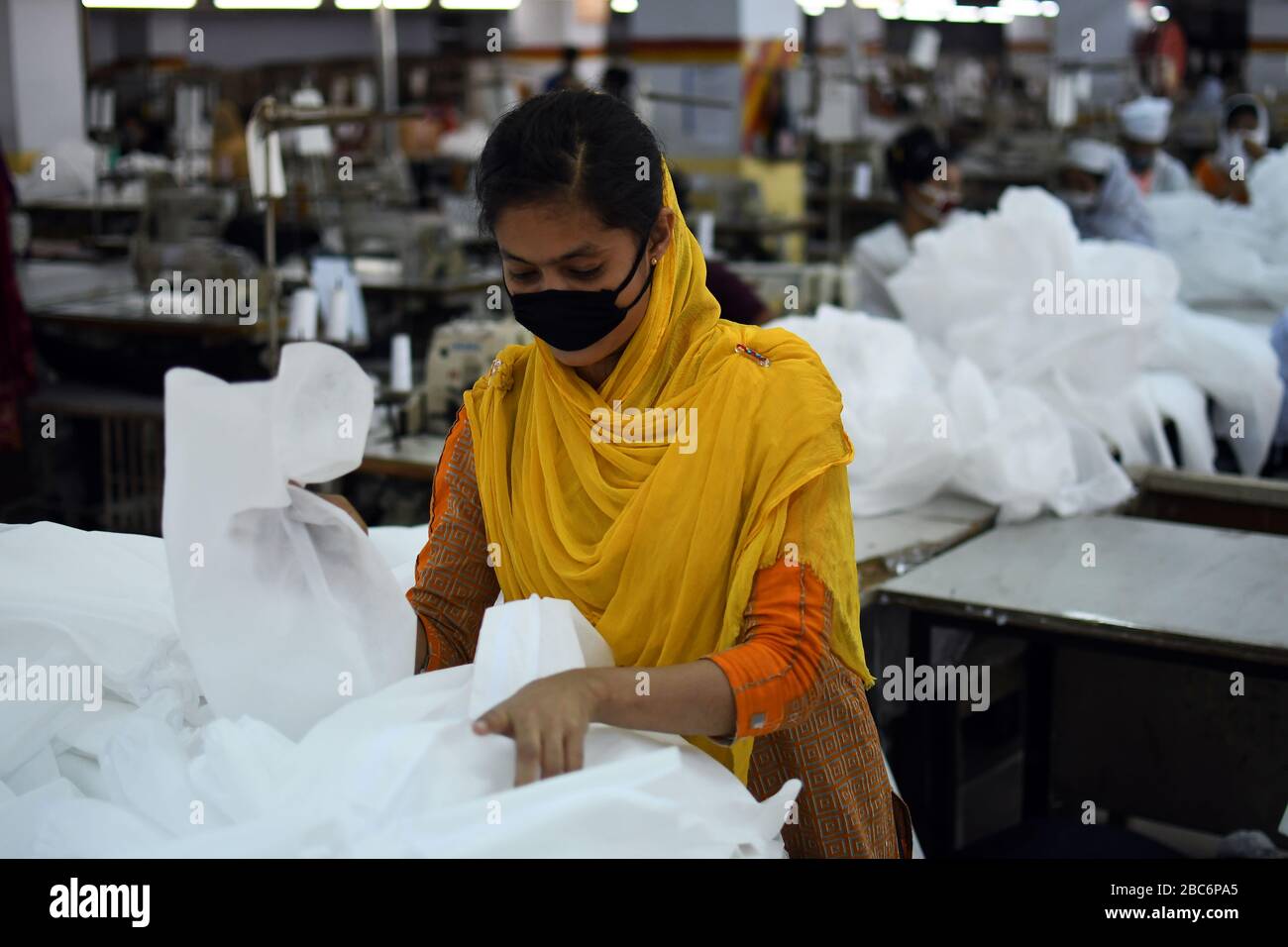 Bangladeschische Bekleidungsarbeiter bringen in einer Fabrik Schutzkleidung inmitten von Bedenken über die Ausbreitung der Coronavirus-Krankheit (COVID-19) in Dhaka, Bangladesch Stockfoto