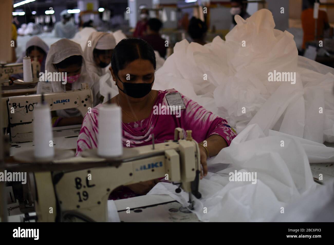 Bangladeschische Bekleidungsarbeiter bringen in einer Fabrik Schutzkleidung inmitten von Bedenken über die Ausbreitung der Coronavirus-Krankheit (COVID-19) in Dhaka, Bangladesch Stockfoto