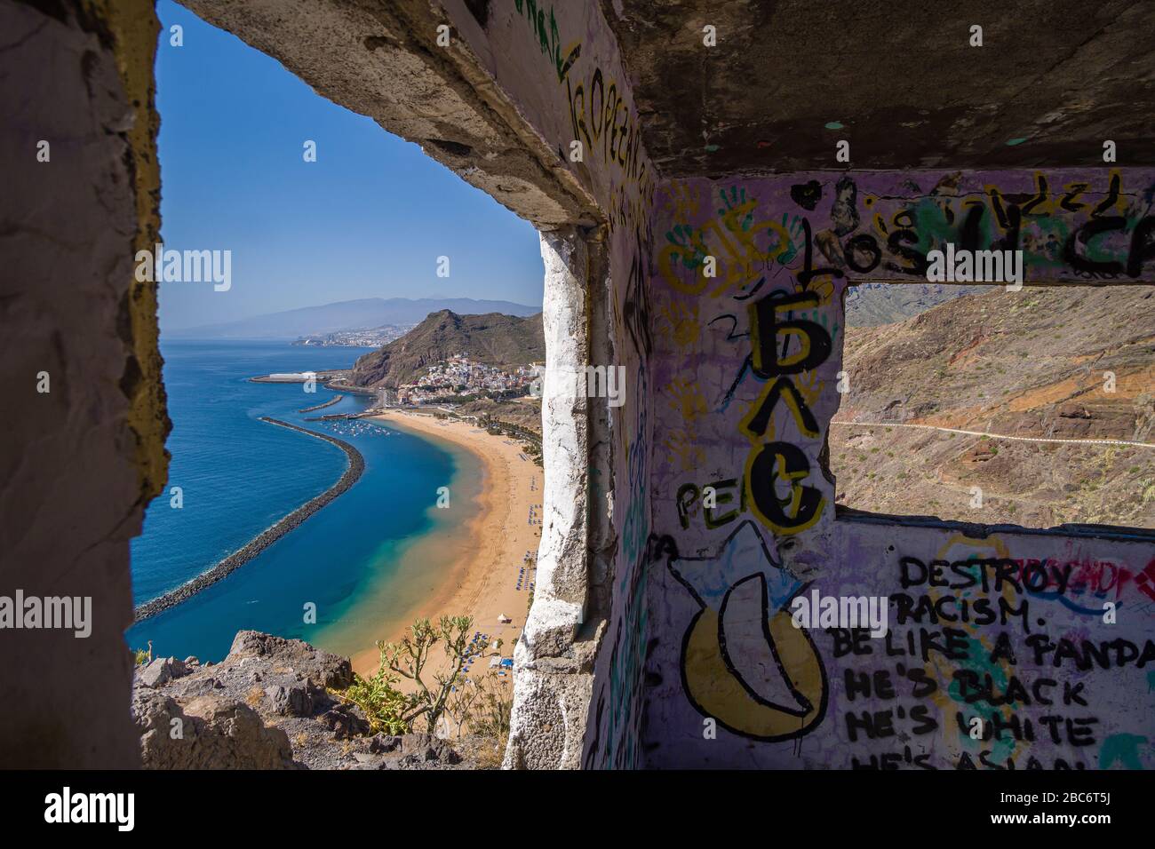 Luftbild am künstlichen, weißen Strand Playa de Las Teresitas und den bunten Häusern von San Andres aus einem zerstörten Gebäude Stockfoto