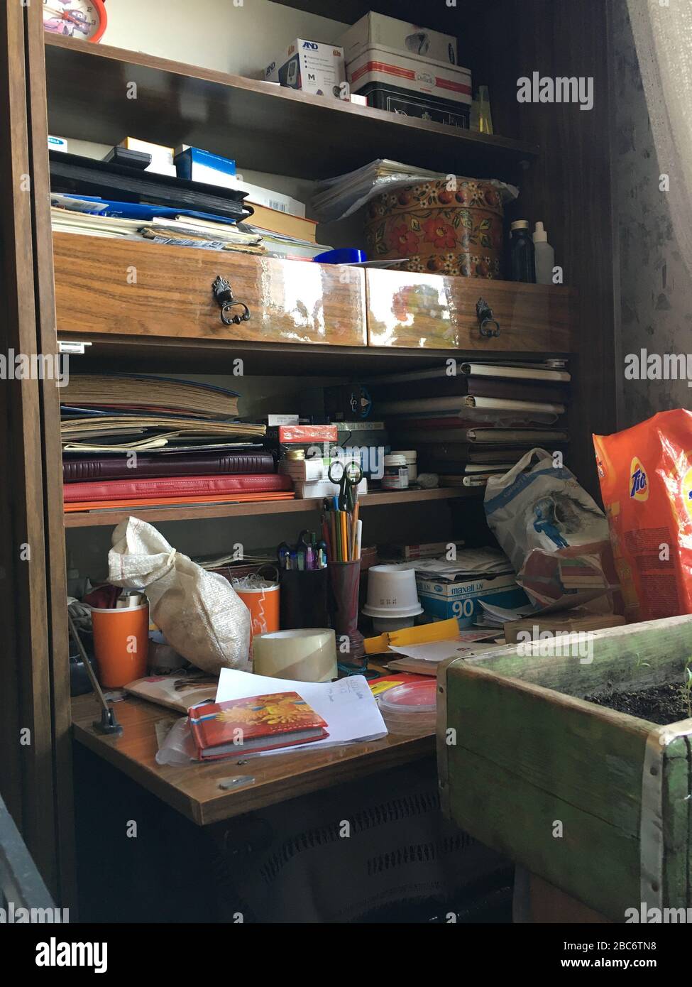 Das Chaos auf dem Tisch beim Großvater. Pljuschkina-Syndrom. Ohne Menschen. Verschiedene Dinge, Alben, Notizbücher auf dem Tisch. Hoarding. Stockfoto