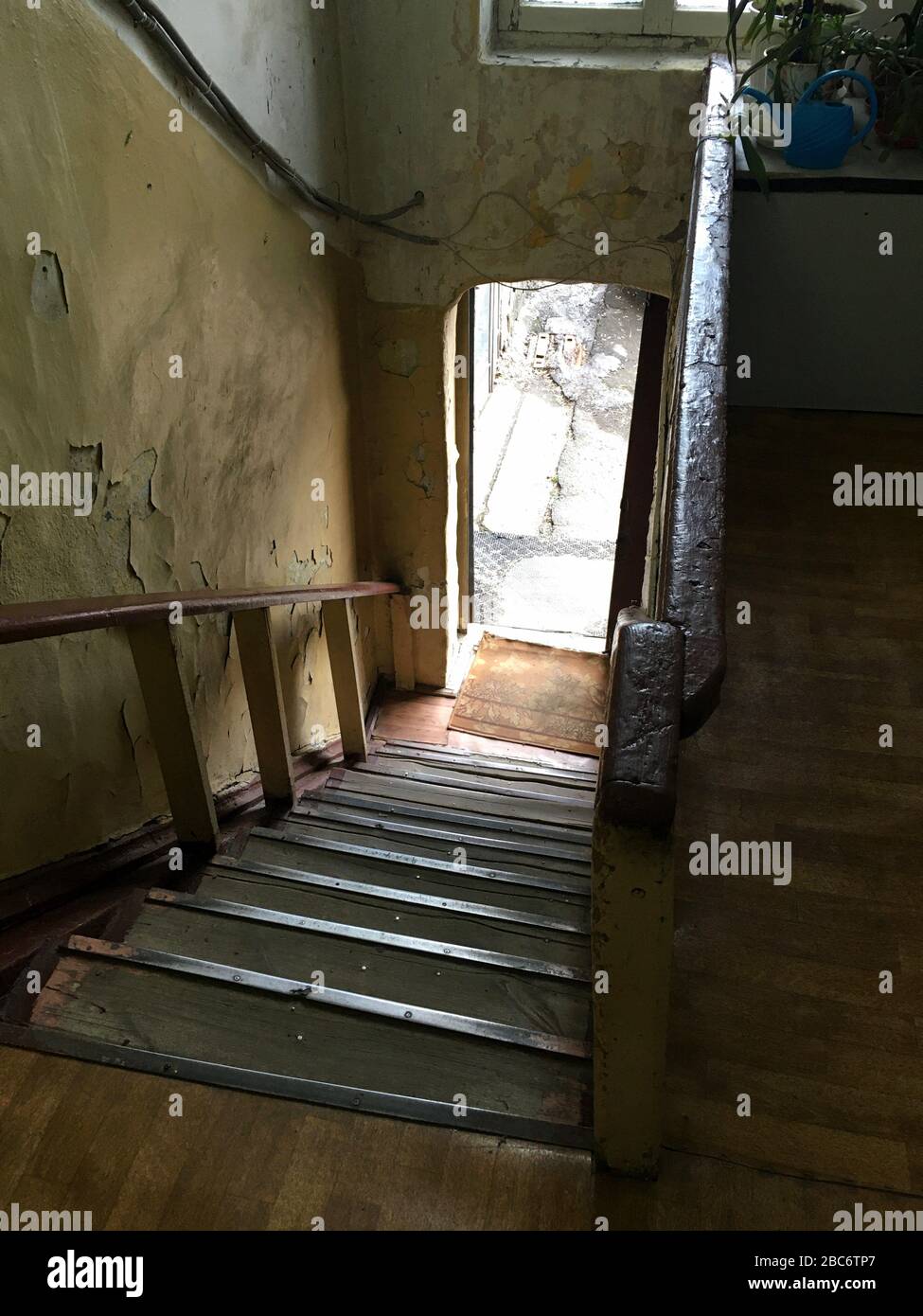 Altes Haus. Durchgang in einem verlassenen Korridor. Treppe hinunter zur Straße. Gerissene Wände. Keine Leute gehen aus Stockfoto
