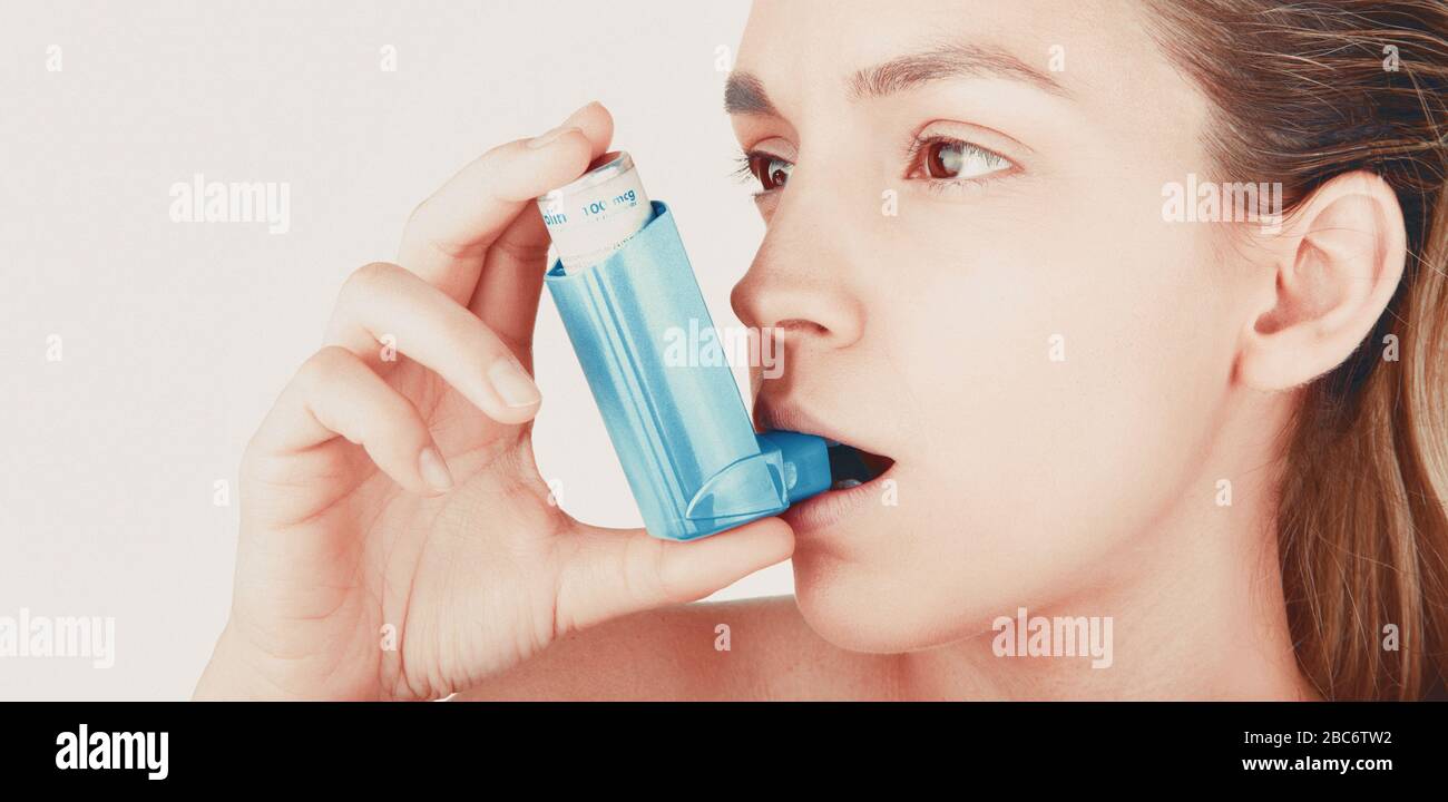 Junge Frau, die Inhalator bei asthmatischem Angriff zu Hause verwendet, Nahaufnahme, weißer Hintergrund Stockfoto
