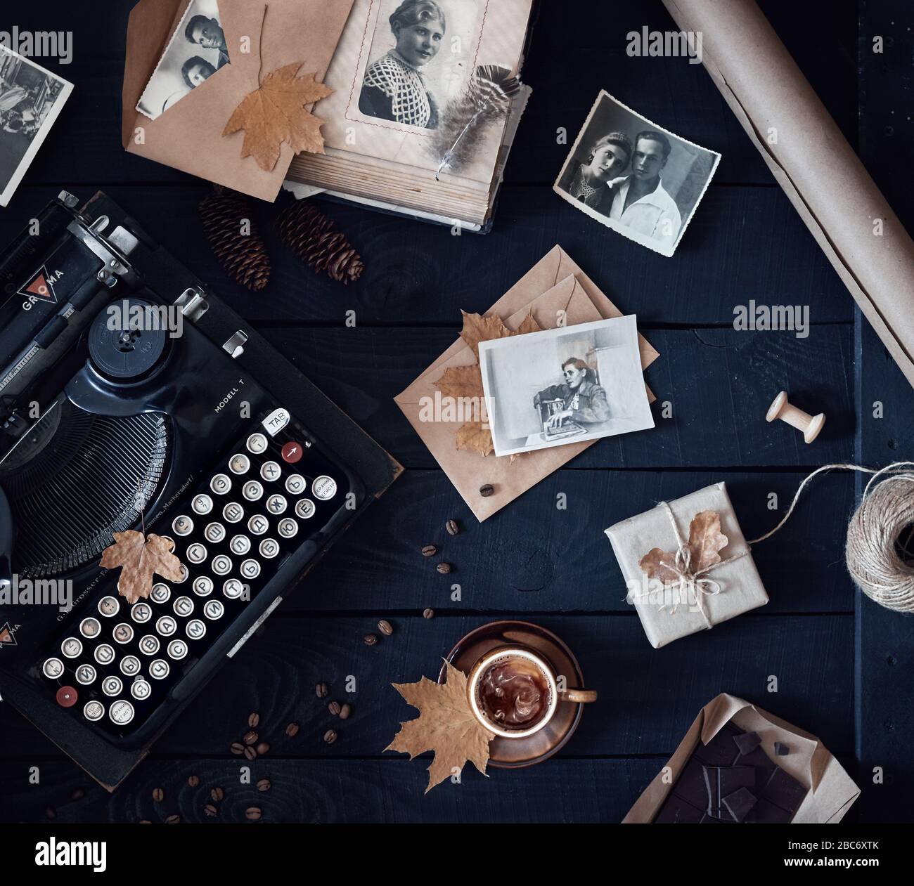 MOSKAU, RUSSLAND - 3. APRIL 2020: Illustratives redaktionelles Foto mit alten Fotos von Mann und Frau in der Nähe der alten russischen Schreibmaschine, Tasse Kaffee, dunkles Cho Stockfoto