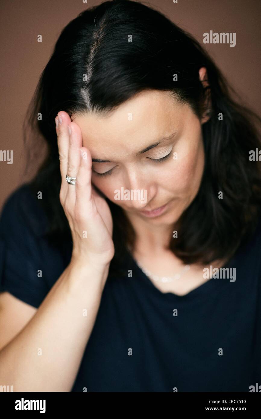 Frau Mädchen mit geschlossenen Augen berührt Tempel mit schmerzhaftem Gefühl im Kopf, mit Migräne oder Kopfschmerzen, oder fühlen müde, gestresst, überarbeitet. Stockfoto