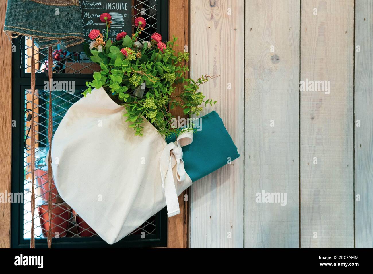 Pflanzen Sie in einer Tasche Dekoration hängen an einer Stahlhaltewand. Stockfoto