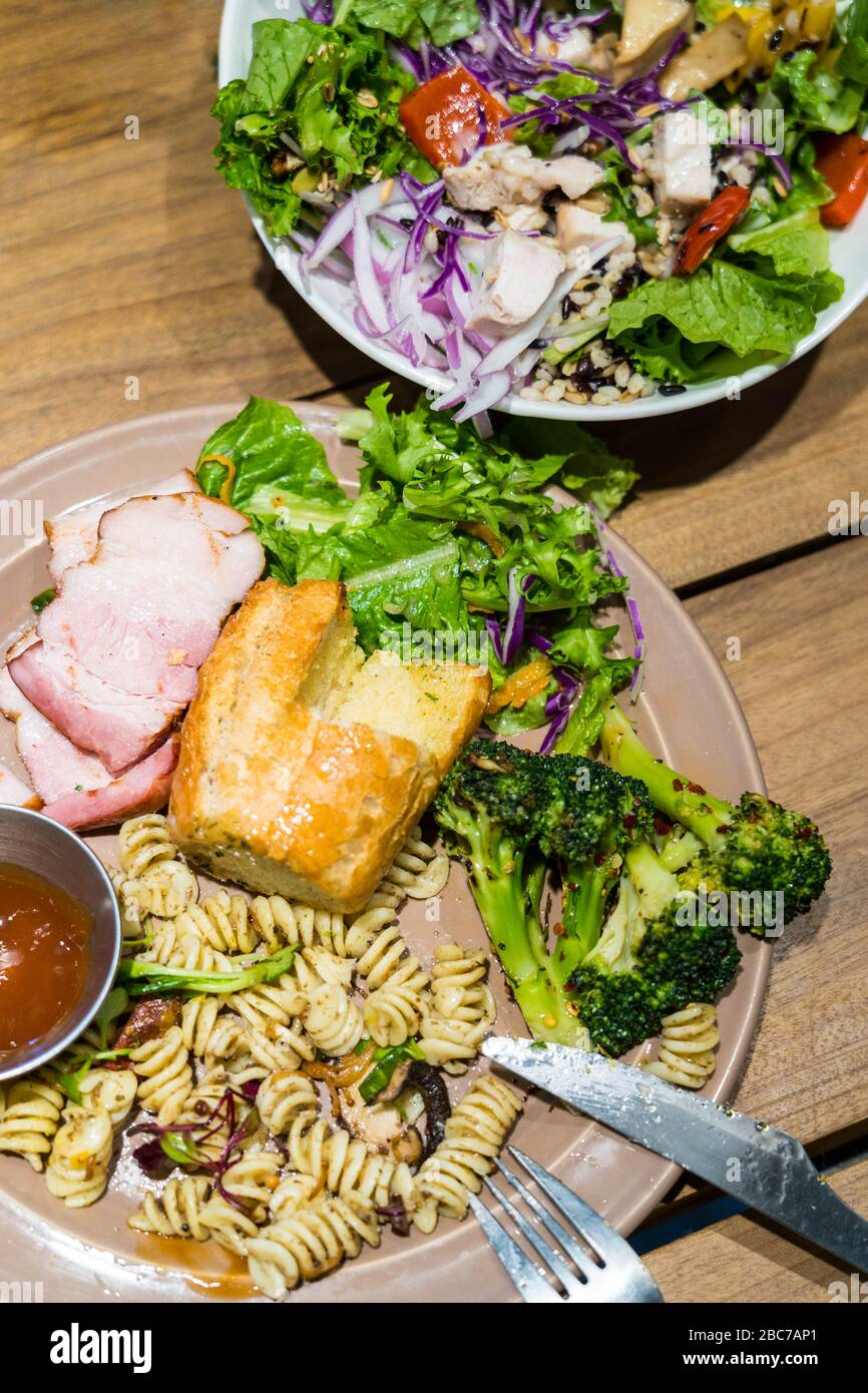 Draufsicht Bild der Salatschüssel und Gemüseteller. Gesunde Ernährung Essen auf einem Holztisch. Stockfoto