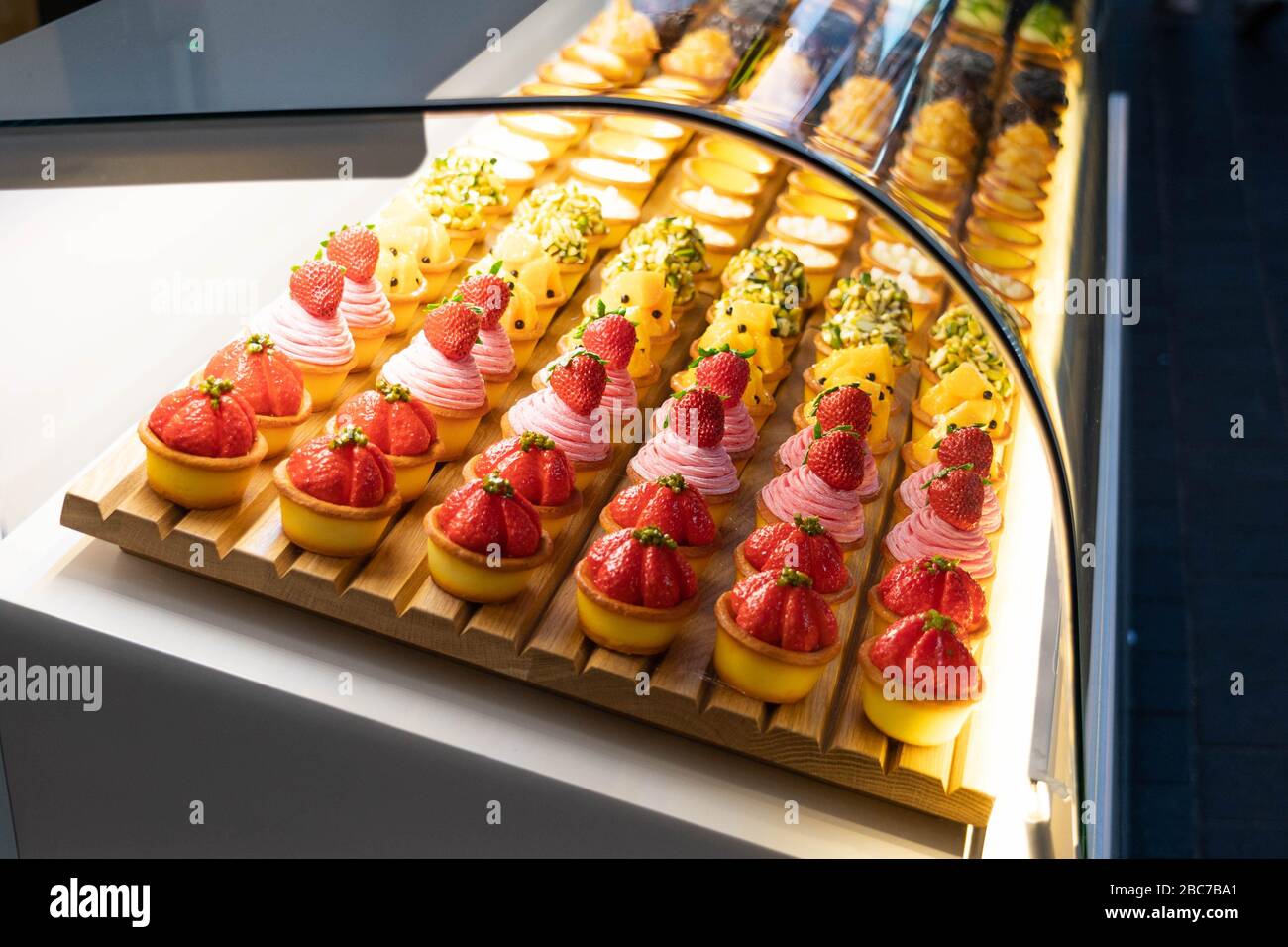 Verschiedene Geschmacksrichtungen von Obst Mini Cupcake Kuchen Kuchen Desserts in einem transparenten Glasschrank angezeigt. Stockfoto