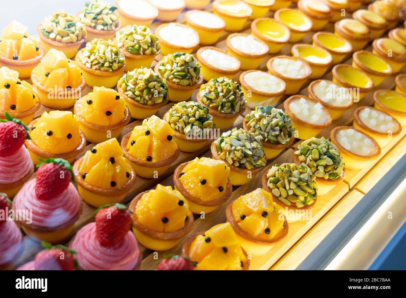 Verschiedene Geschmacksrichtungen von Obst Mini-Kuchen Desserts in einem transparenten Glasschrank angezeigt Stockfoto