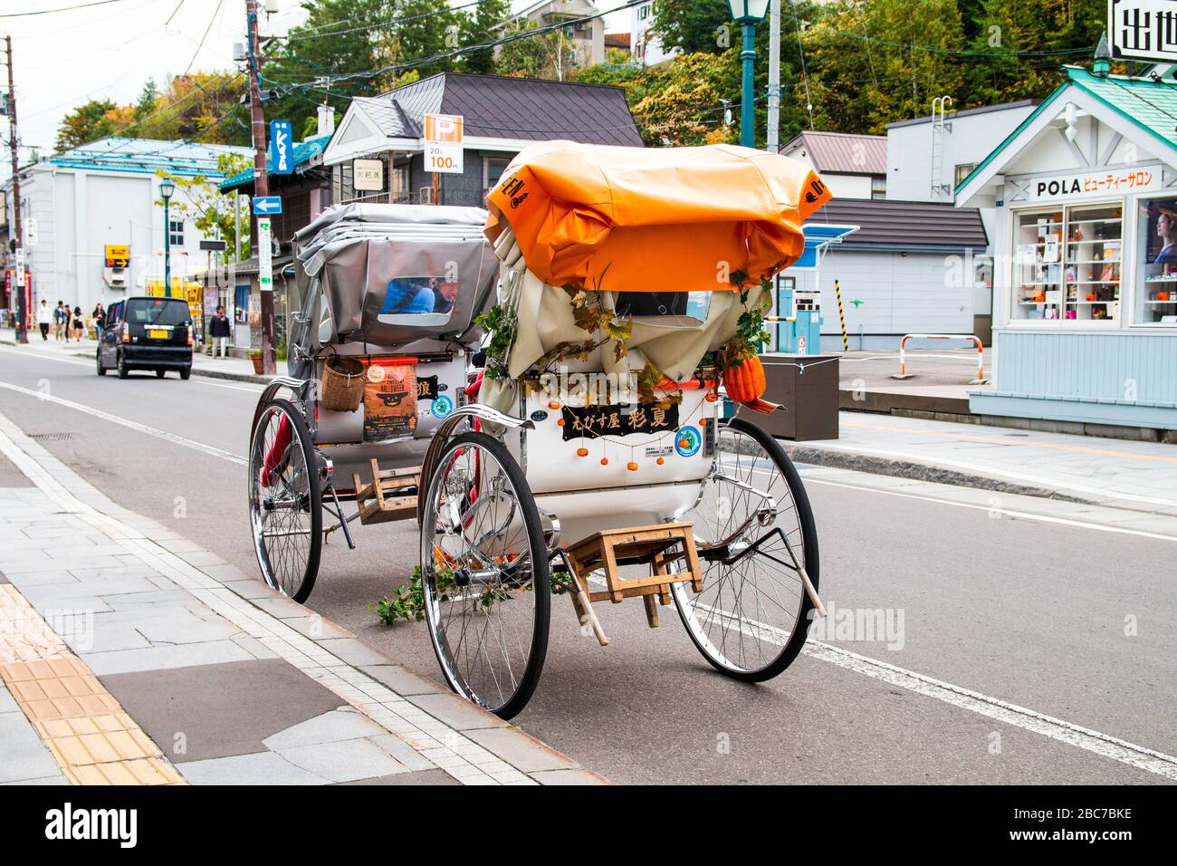 Traditionelle japanische Dreirad Fahrt mit Pflanzendekorationen Parks auf  der Straße.drei Rädern öffentlichen Fahrzeug in Japan Stockfotografie -  Alamy