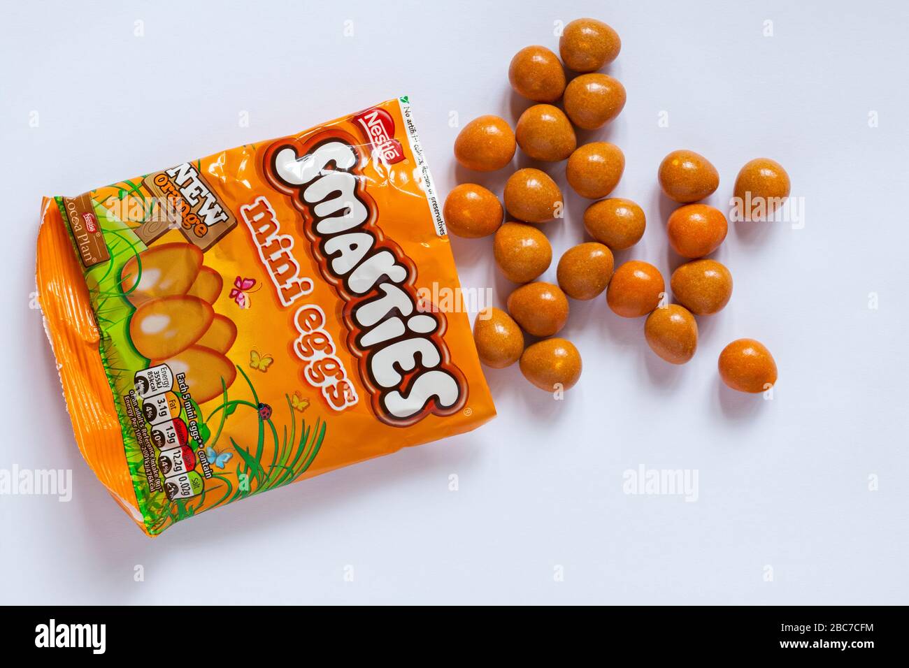 Packung Nestle Smarties orangefarbene Mini-Eier offen mit Inhalt verschüttet verschüttet isoliert auf weißem Hintergrund - bereit für Ostern Stockfoto