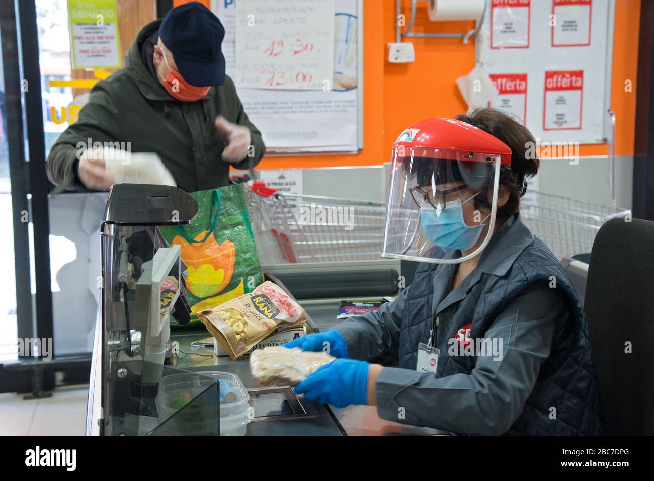 Campobasso, Molise Region, Italien: EIN Kassierer arbeitet mit einer Maske und einem Helm mit einem Schutzvisier während des Coronavirus Notfalls in Italien. Stockfoto