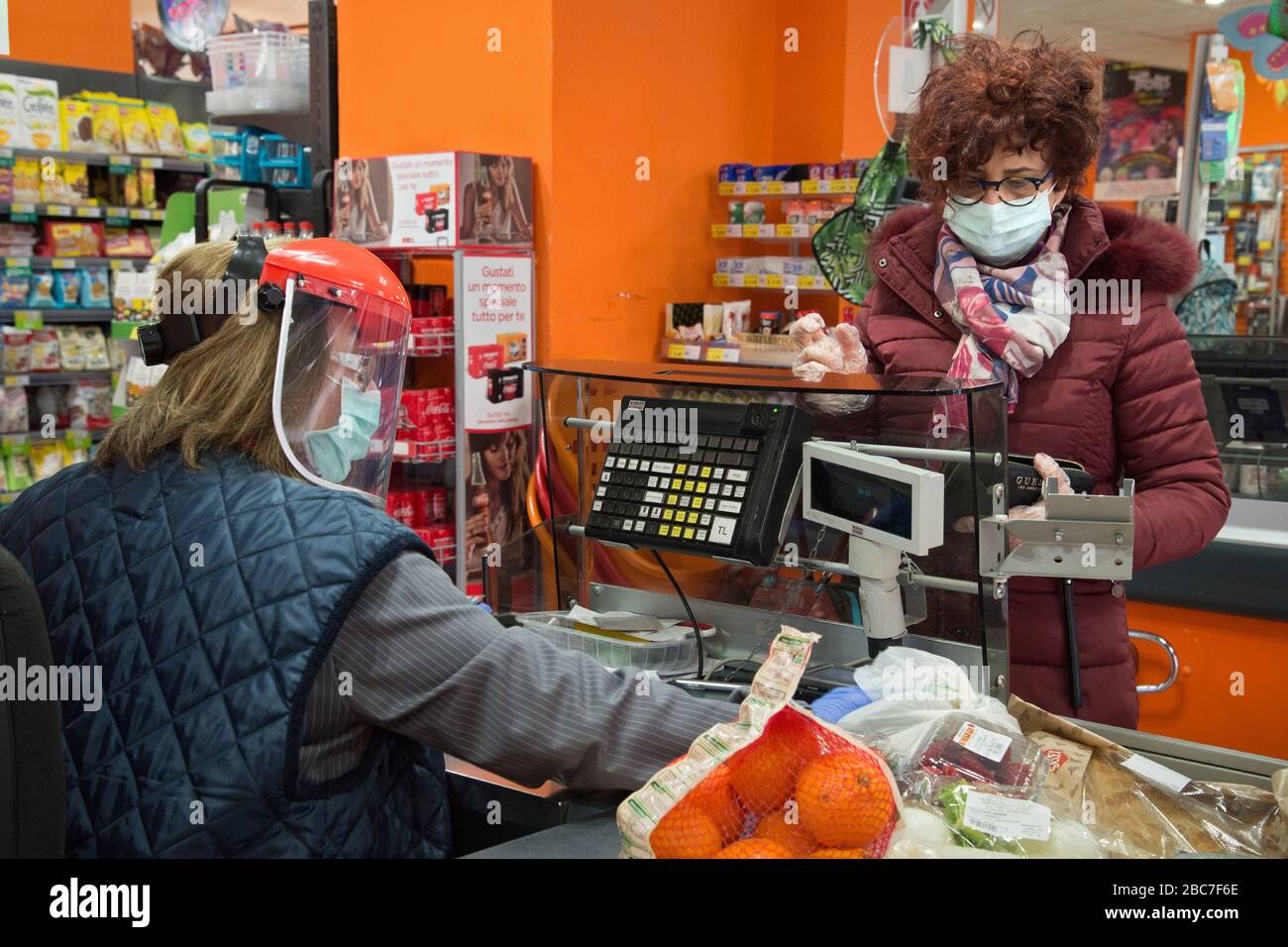 Campobasso, Molise Region, Italien: EIN Kassierer arbeitet mit einer Maske und einem Helm mit einem Schutzvisier während des Coronavirus Notfalls in Italien. Stockfoto