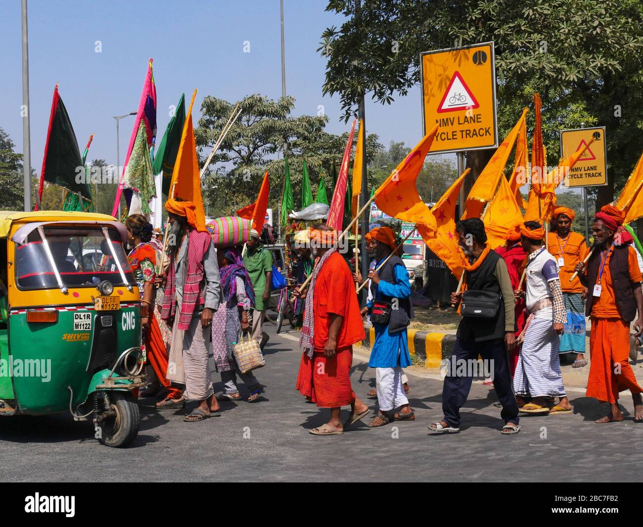 Neu-Delhi, Indien - März 2018: Menschen in traditioneller indianischer Kleidung, die auf der Straße marschieren und verschiedene Flaggen in Neu-Delhi halten. Stockfoto