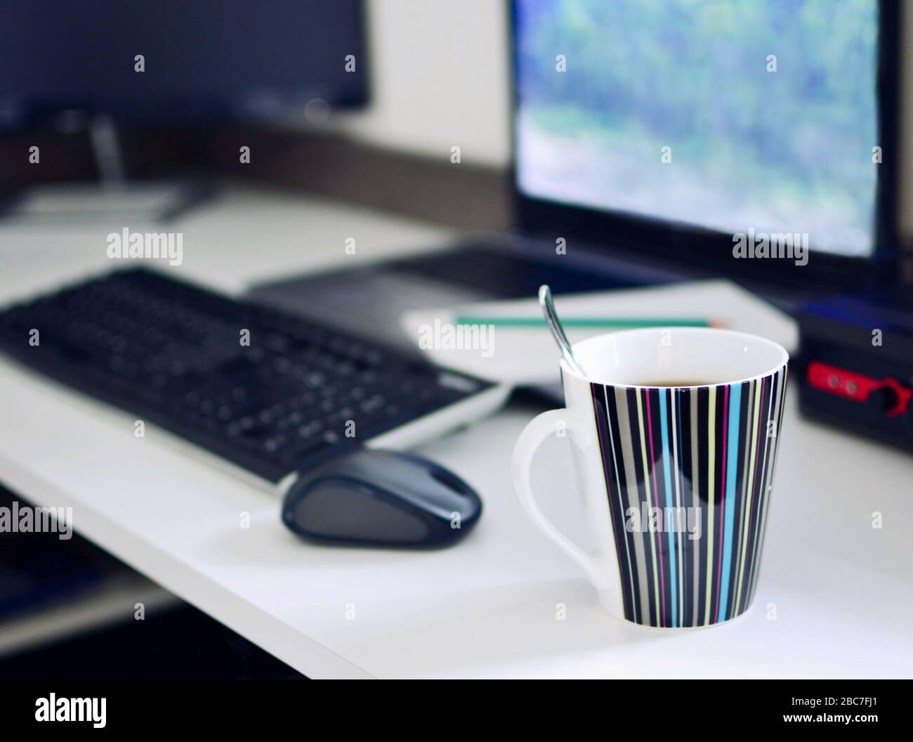 Schreibtisch mit Laptop, Tastatur, Maus, Notizblock und einer Tasse Kaffee. Arbeiten von zu Hause aus konzeptionelle Aufnahme. Im Vordergrund mit einer Tasse Kaffee Stockfoto