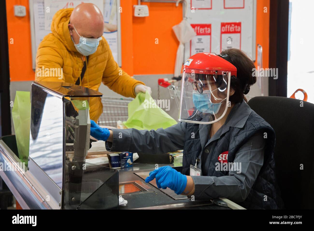 Campobasso, Molise Region, Italien: EIN Kassierer arbeitet mit einer Maske und einem Helm mit einem Schutzvisier während des Coronavirus Notfalls in Italien. Stockfoto