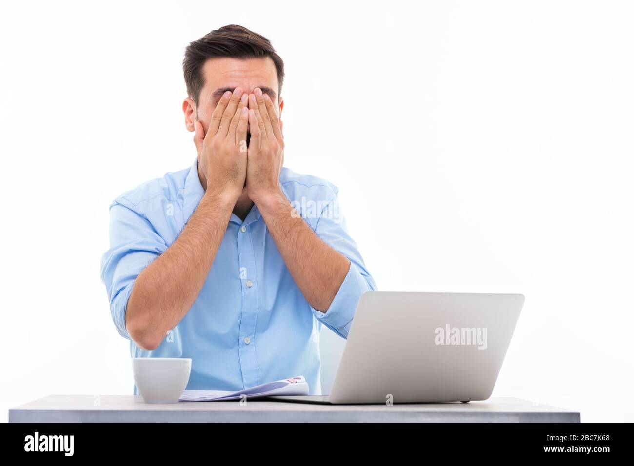 Mann an Schreibtisch mit Laptop Stockfoto