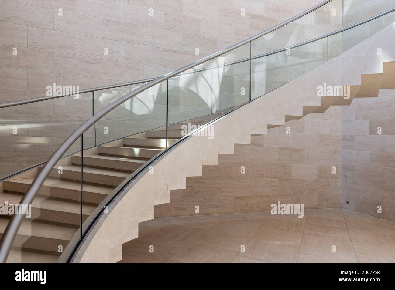 Moderne geschwungene Treppe aus Marmor, Stahl und Glas Stockfoto