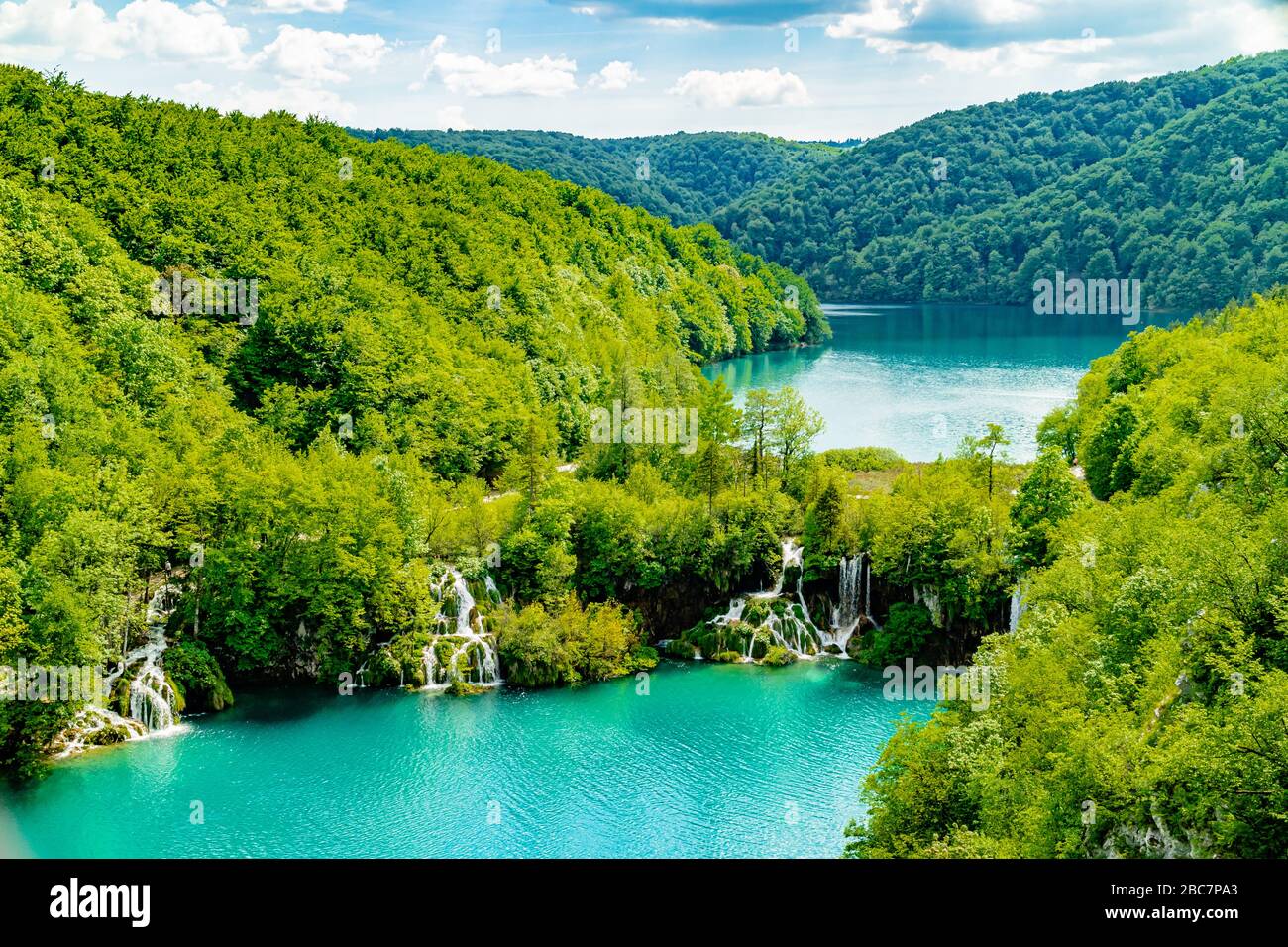 Wasserfälle, die zwischen Seen und von bewaldeten Hügeln umgeben, Nationalpark Plitvicer Seen, Kroatien, Europa. Mai 2017. Stockfoto