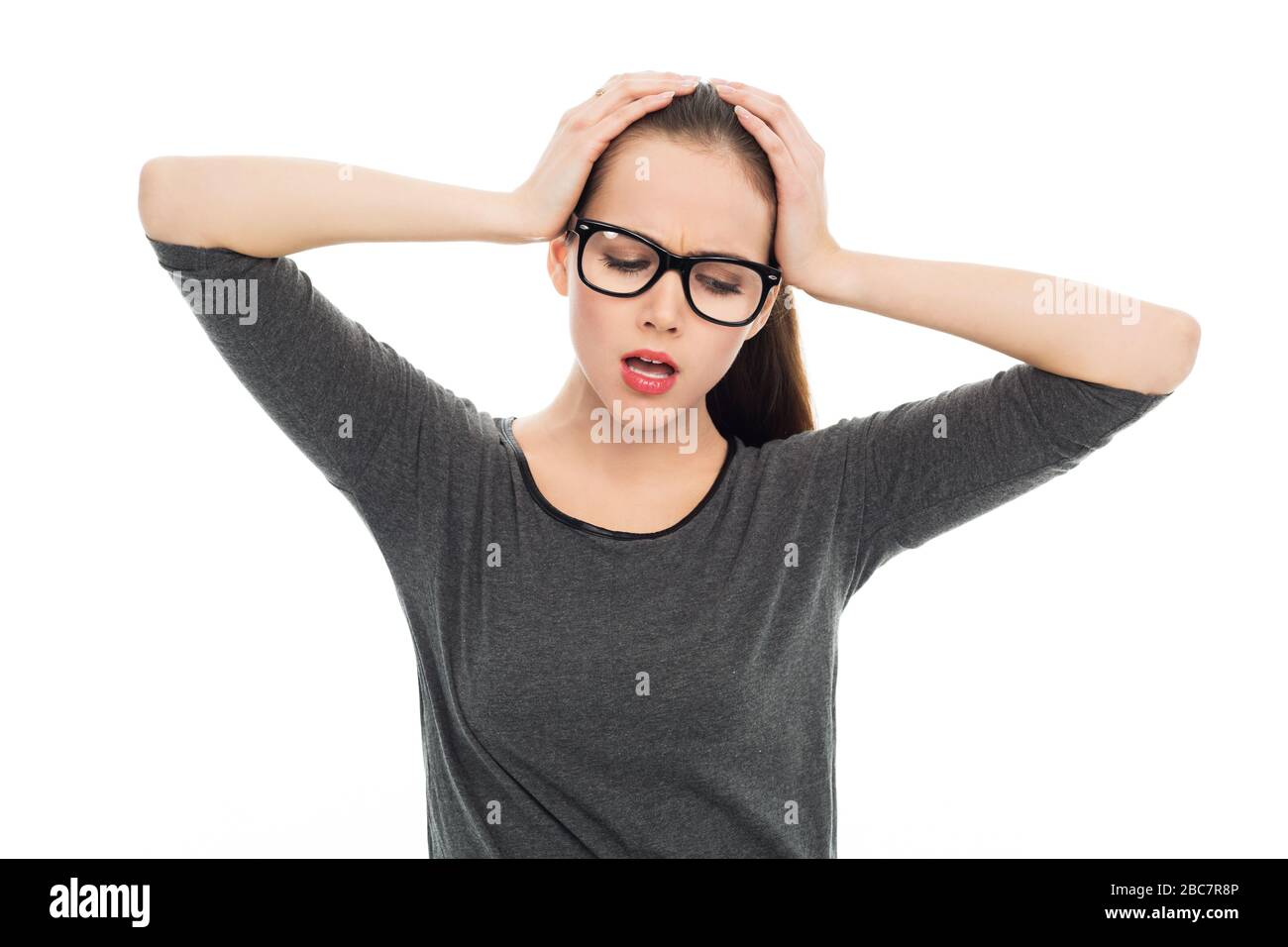 Frau, die ihren Kopf über weißem Hintergrund hält Stockfoto