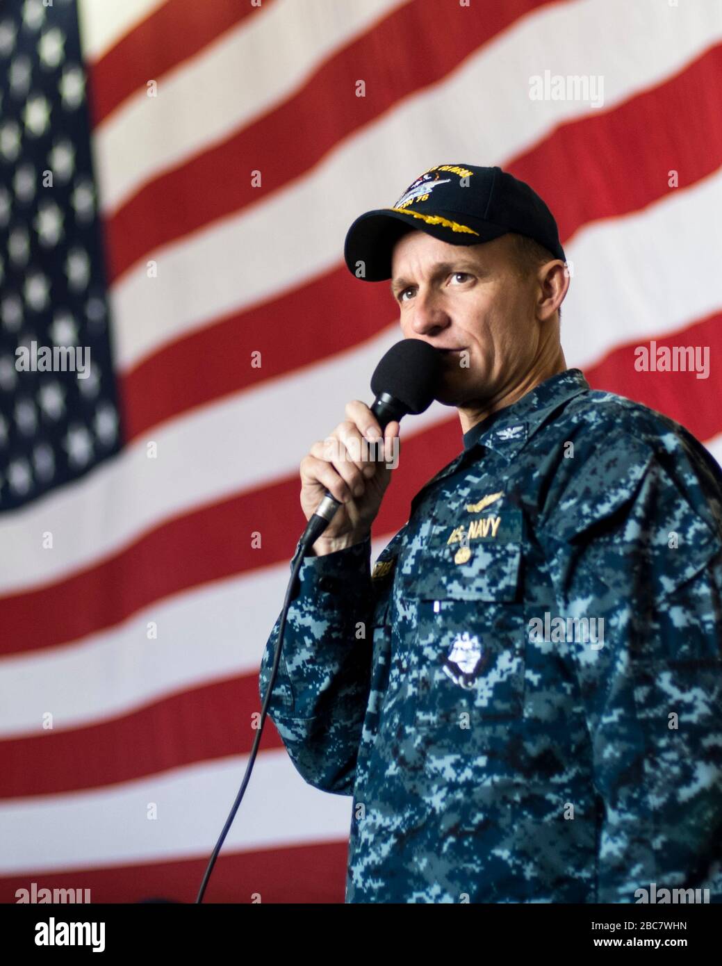 US-Navy Capt Brett Crozier, kommandierender Offizier des Flugzeugträgers USS Theodore Roosevelt spricht mit Seeleuten während einer Zeremonie in der Hangarbucht am 2. Juni 2016 in Yokosuka, Japan. Crozier wurde vom 31. März 2020 entlastet, nachdem er einen vierseitigen Brief an seine Vorgesetzten geschrieben hatte, in dem er mit ihnen plädierte, Maßnahmen zu ergreifen, um die Verbreitung der COVID-19-Fälle auf seinem Schiff zu verringern. Stockfoto