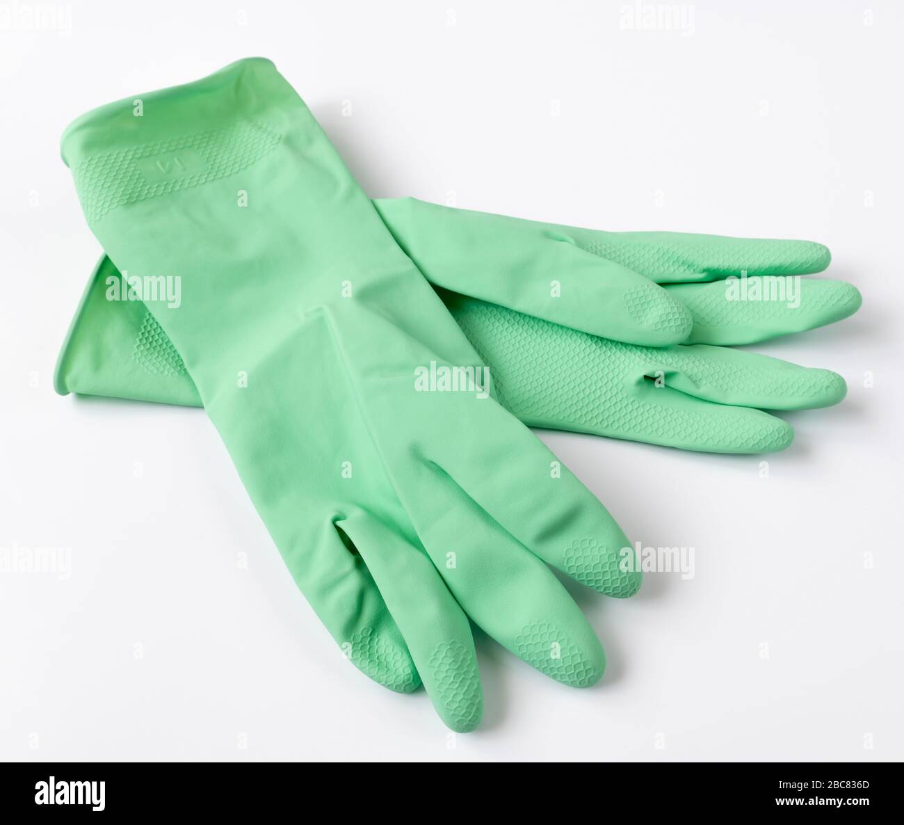 Spülhandschuhe aus grünem Latex auf weißem Hintergrund Stockfoto