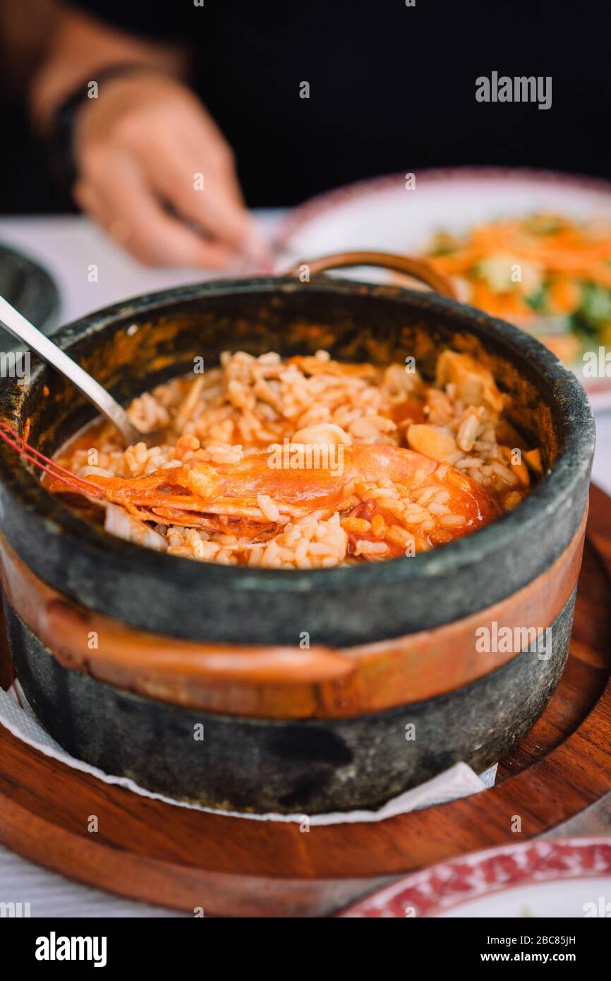 Nationale Küche von Kap Verde: Cachupa mit Garnelen in traditionellen Stein Schüssel. Stockfoto