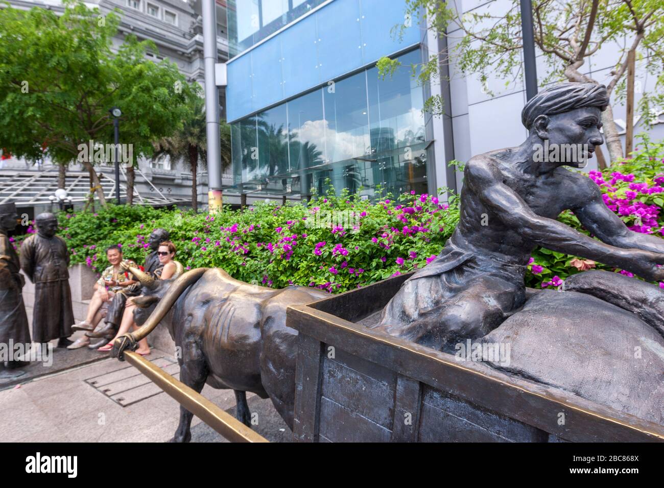 Tourist mit der Skulptur von Alexandre Laurie Johnston, The River Merchants, Skulptur von Aw Tee Hong, Maybank Tower, Singapur Stockfoto