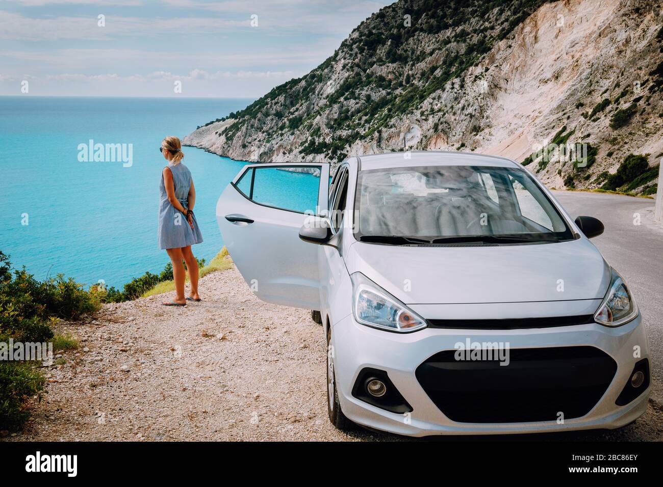 Frauen in der Nähe eines Mietwagens mit offener Tür am Myrtos Beach. Konzept für die Berufung auf Reisen. Kefalonia, Ionisches Meer, Griechenland. Stockfoto