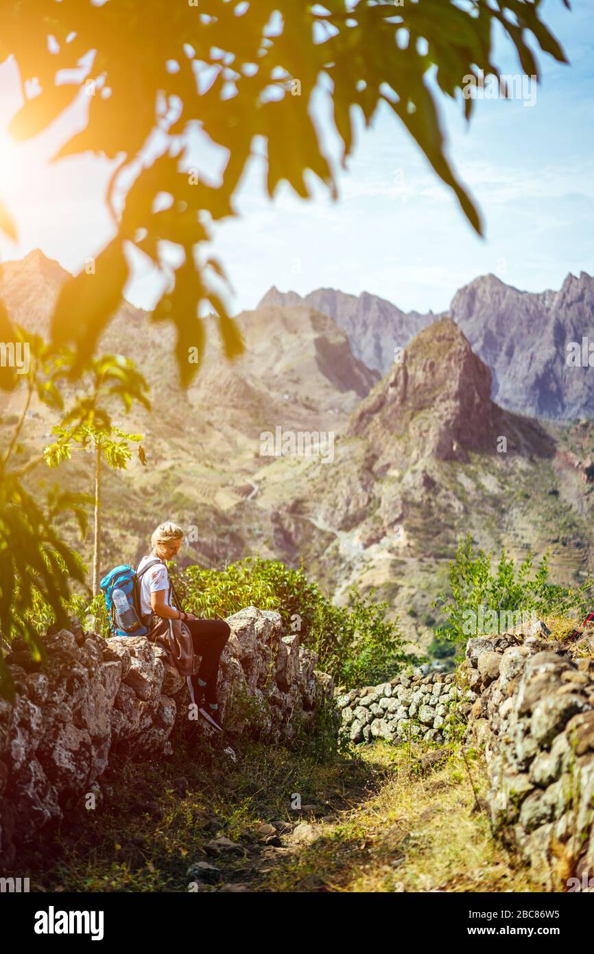 Mädchen ruht auf dem Wanderweg, der durch arides, felsiges Gelände in Richtung Coculli-Dorf auf Santo Antao Kap Verde führt. Stockfoto