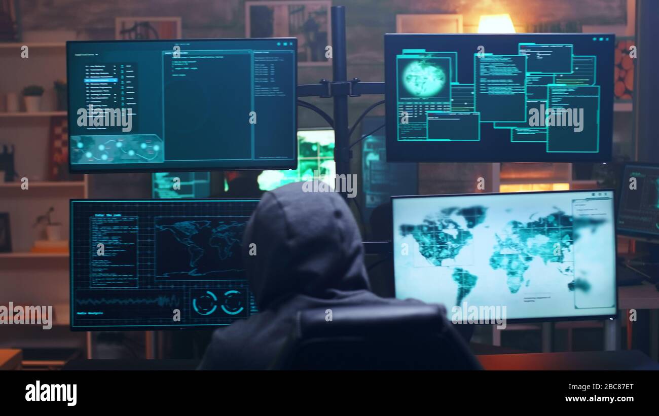 Rückansicht von Cyberterroristinnen mit Super-Computer im dunklen Raum. Hackerteam. Stockfoto
