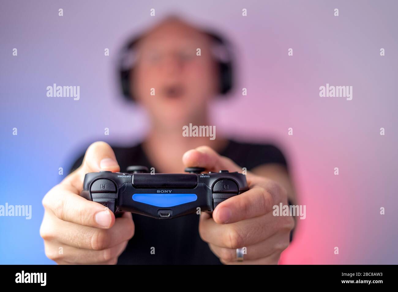 Gamer mit Kopfhörern und Gamepad haben viel Spaß. Gamepad in Stockfoto