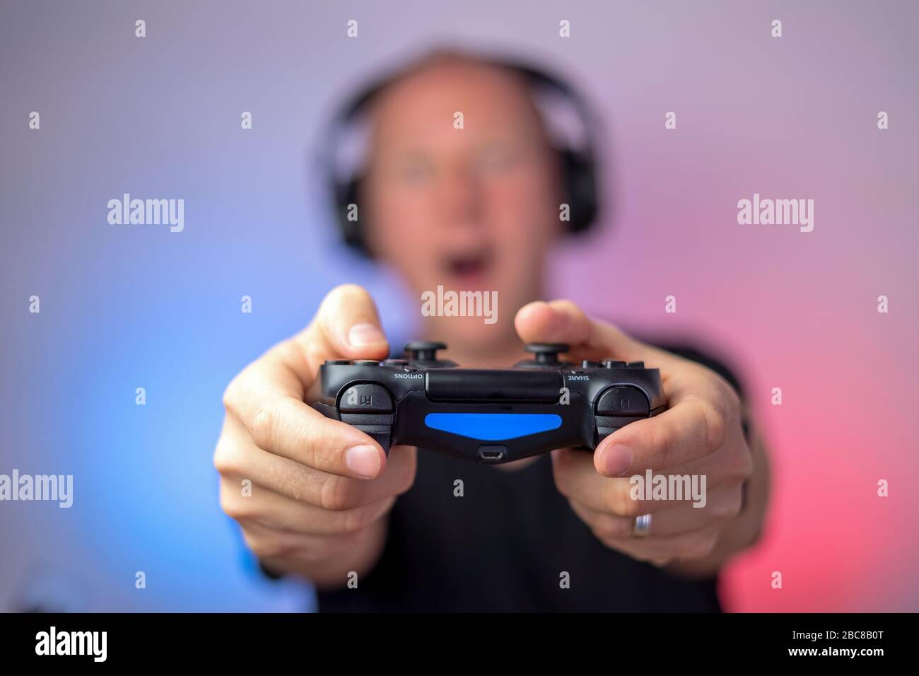 Gamer mit Kopfhörern und Gamepad haben viel Spaß. Gamepad in Stockfoto