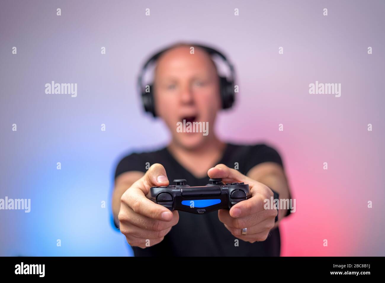 Gamer mit Kopfhörern und Gamepad haben viel Spaß. Gamepad in Stockfoto
