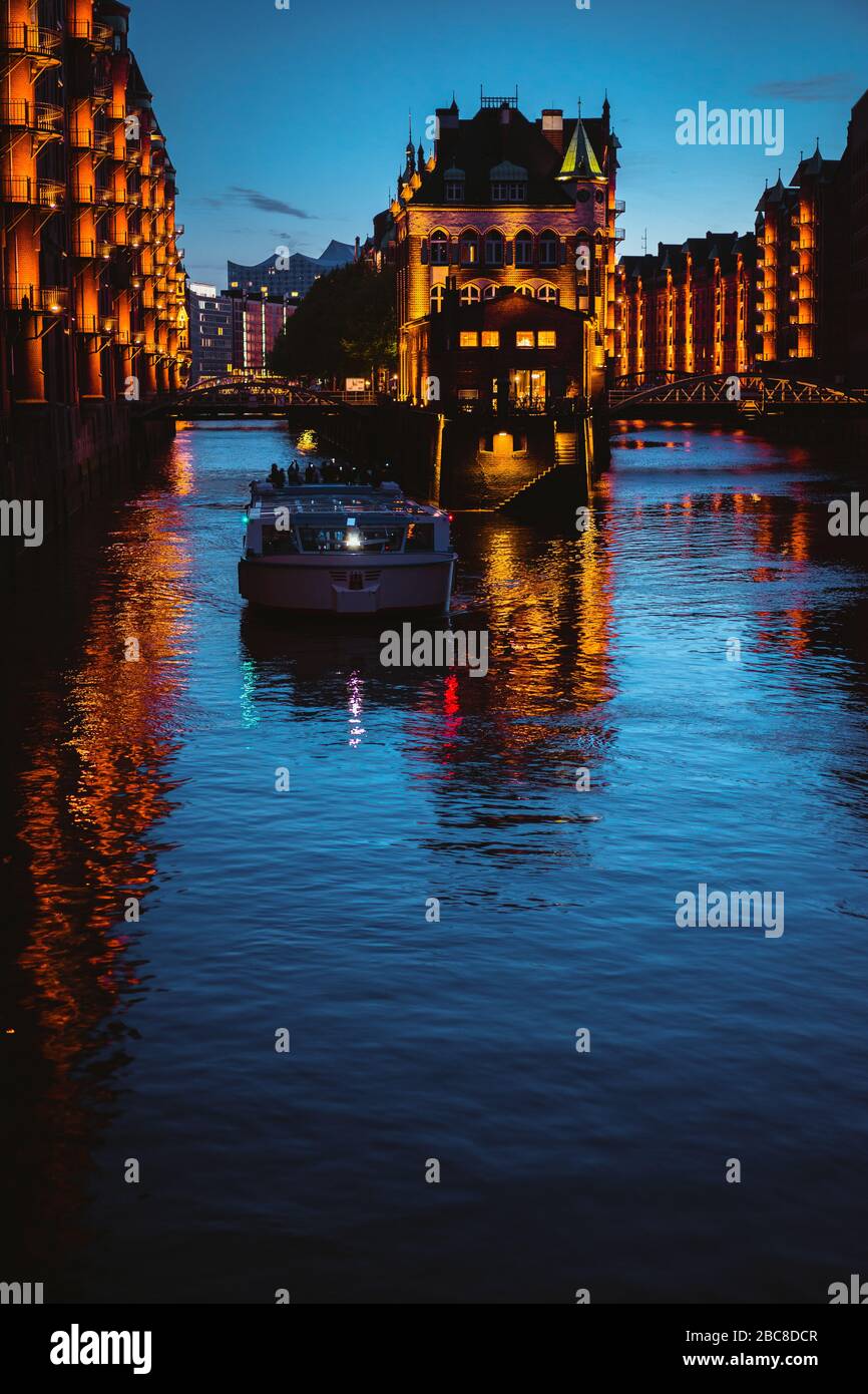 Wasserschloss in alter Speicherstadt oder Lagerviertel, Touristenboot auf einem Kanal. Hamburg, Deutschland. Stockfoto