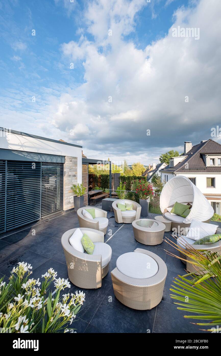 Gartenmöbel aus künstlichem Rattan auf einer großzügigen, exklusiven Terrasse Stockfoto