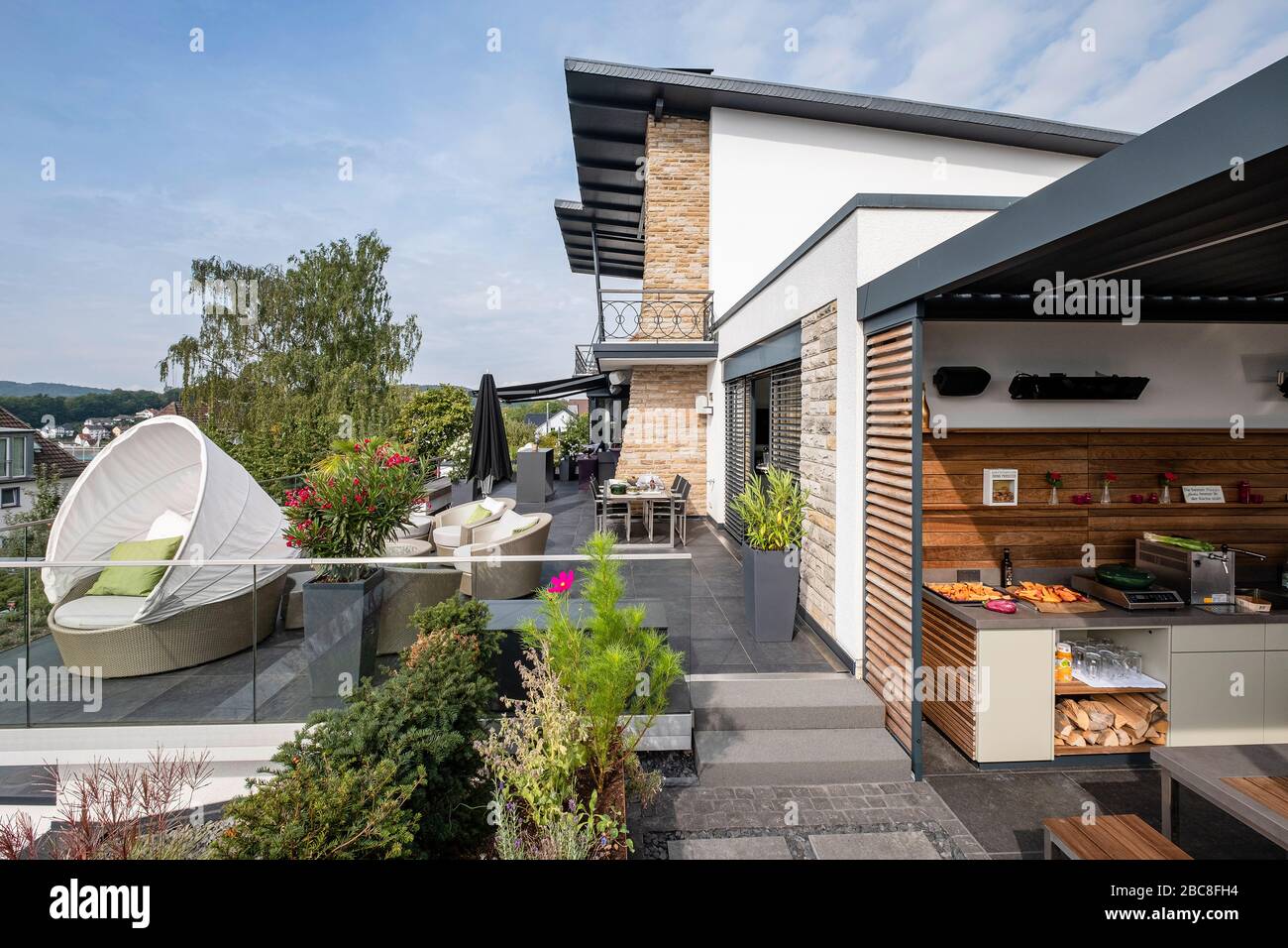 Modernes, exklusives Einfamilienhaus mit großer Terrasse, Gartenmöbel und Außenküche Stockfoto